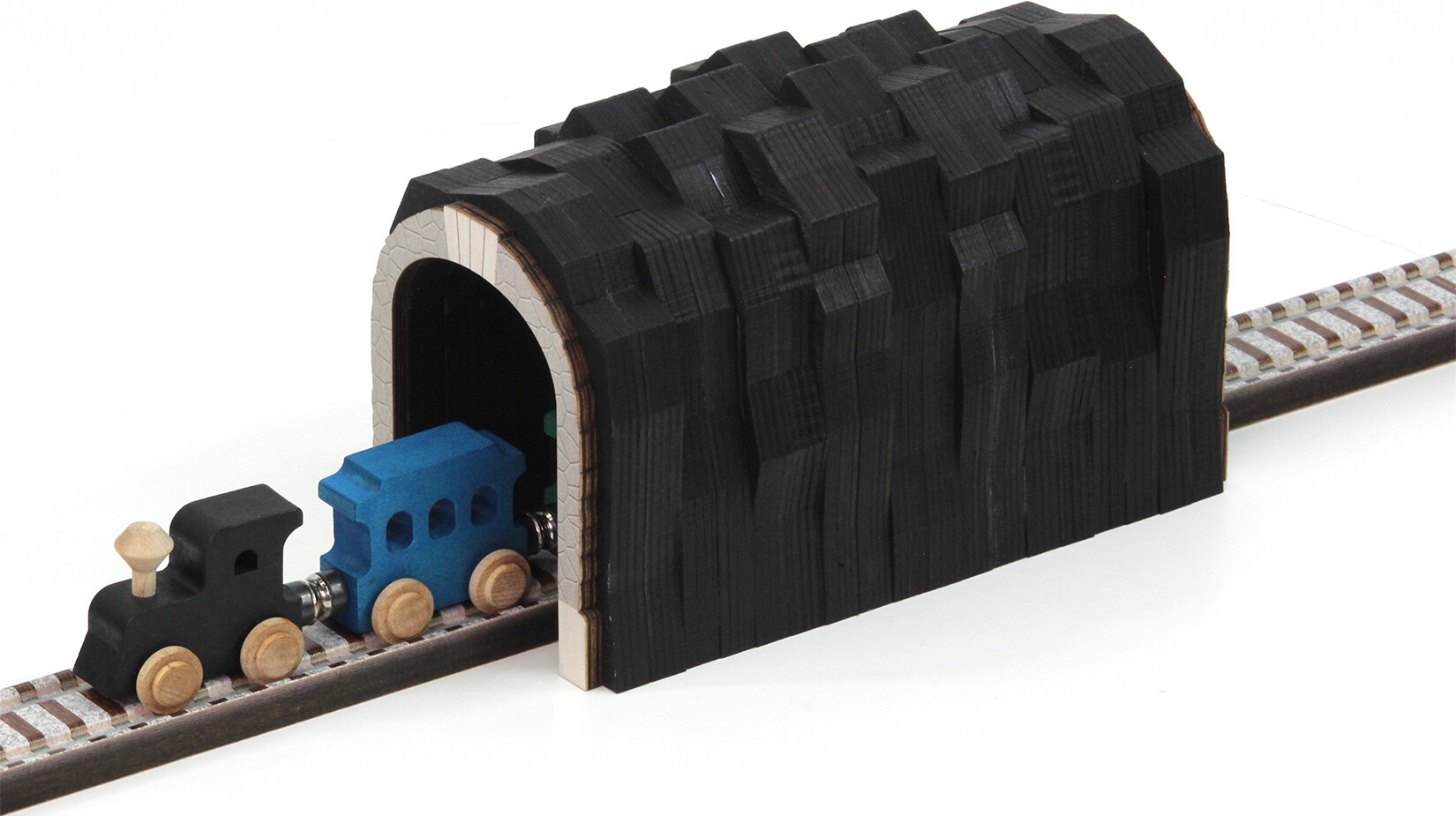 wooden train going through tunnel to the left